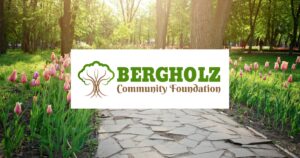 Flowers lining a stone path and the Bergholz Community Foundation logo