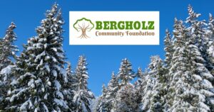 Pine trees covered in snow and the Bergholz Community Foundation logo.