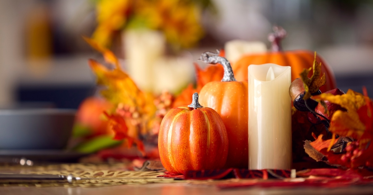 Autumn decorations on a table including pumpkins and candles.