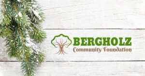 White wood background with a pine branch and the Bergholz Community Foundation logo