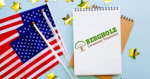 USA flags, gold stars and a notepad with the Bergholz Community Foundation logo