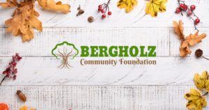 Fall wood background with leaves and cranberries and the Bergholz Community Foundation Logo