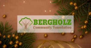 A brown background image with gold ornaments, ribbon, and pine tree branches with the Bergholz Community Foundation logo in the middle