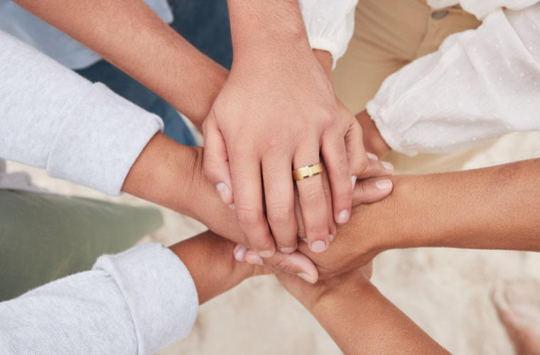 A group of people stacking their hands on top of each other