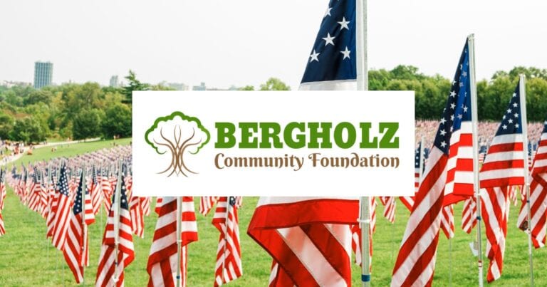 Image of USA flags lined up in a field with the Bergholz Community Foundation logo centered over the image.