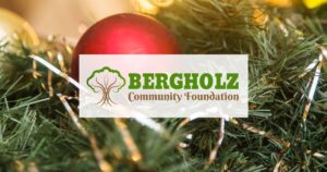 Image of an red ornament on a tree branch with the Bergholz Community Foundation logo in the middle of the picture.