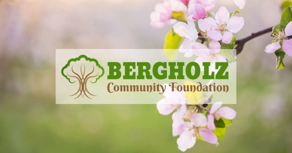 Pink flowers on a tree branch with the Bergholz Community Foundation logo overlayed in the middle of the image.